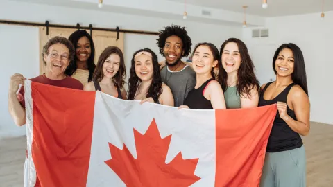 Счастливые люди на фоне канадского флага
